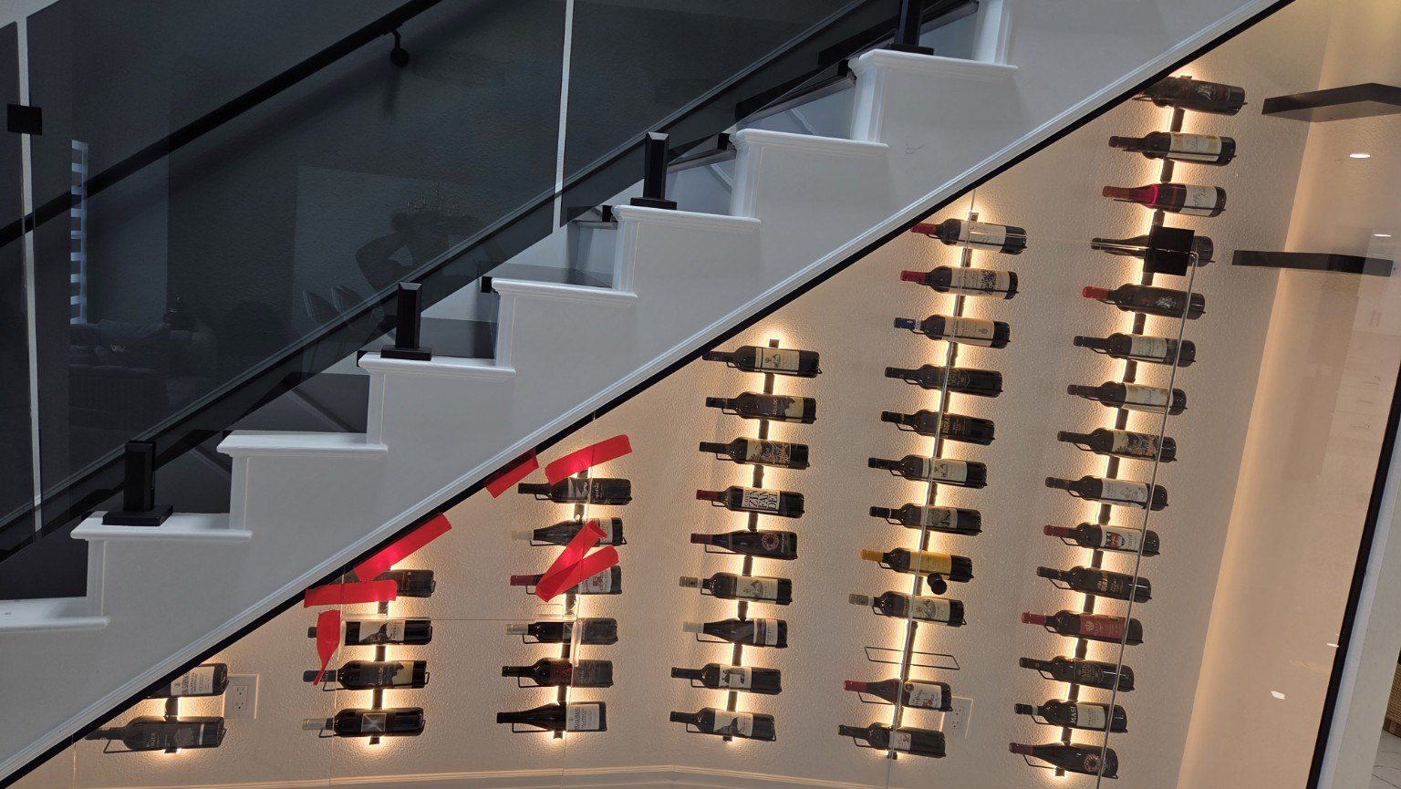 Warm LED lighting on a wine display under a staircase